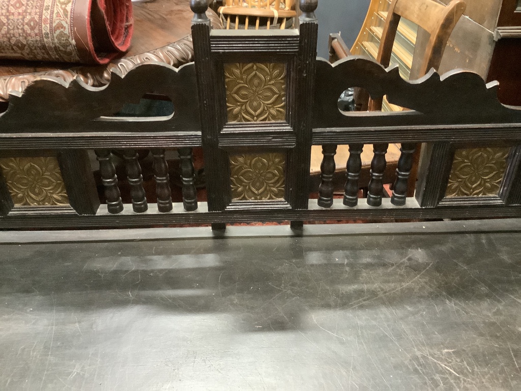 A Victorian Aesthetic period ebonised hall seat, the raised back with embossed glass inset panels, width 182cm depth 61cm height 96cm